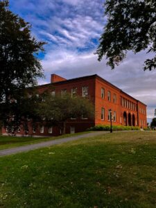 A red brick building sitting on top of a lush green field